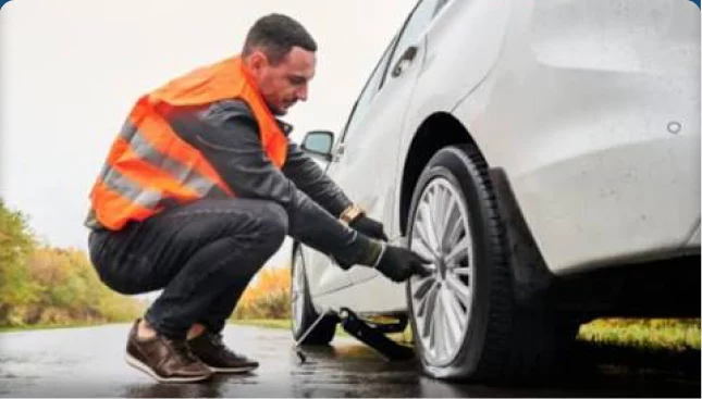 Profissional de colete trocando o pneu de um carro